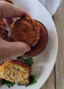 Dipping the Fried Mac and Cheese Balls