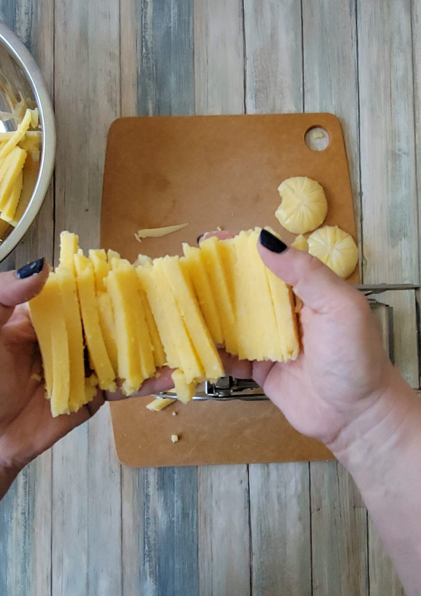 Using a french fry cutter to cut the polenta into fries.